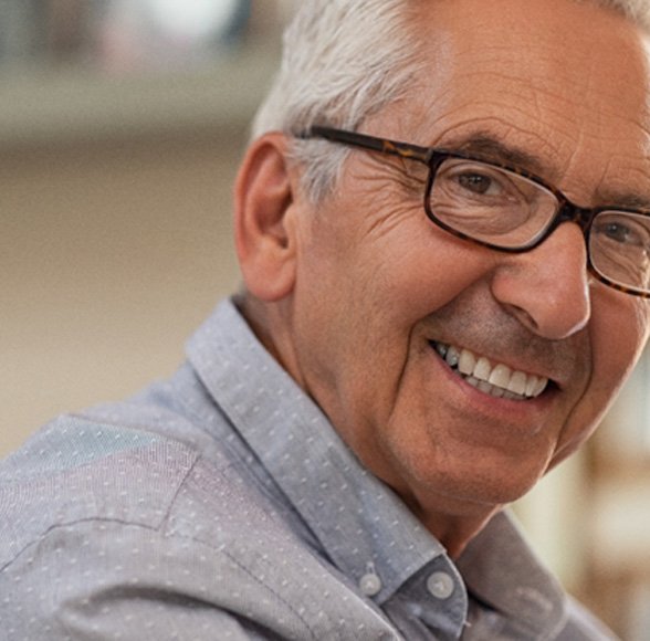 Senior man with glasses sitting and smiling