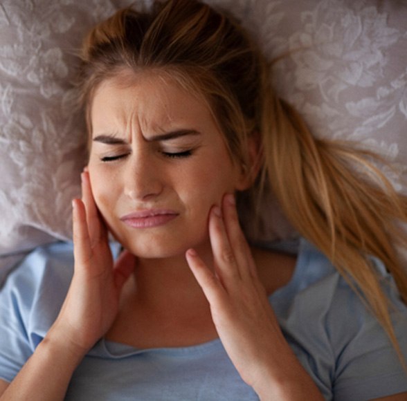 Woman lying in bed with a TMJ disorder