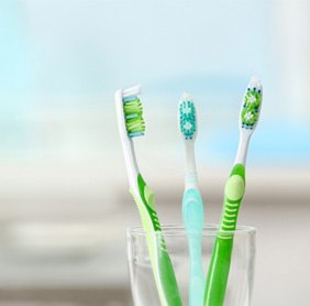 Close-up of toothbrushes in a glass