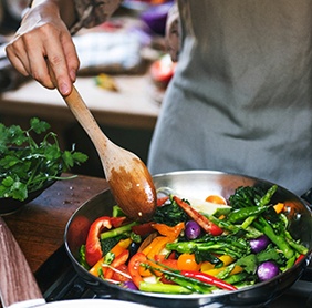 Person cooking vegetables in pan