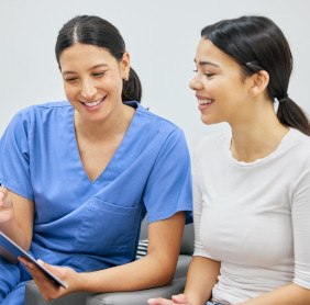 Patient and dental team member looking at clipboard