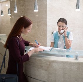 Patient signing paperwork at dental office front desk