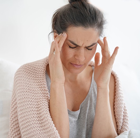 a woman massaging her temples because she has a headache